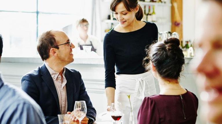 Waitress offering drinking suggestion to customers