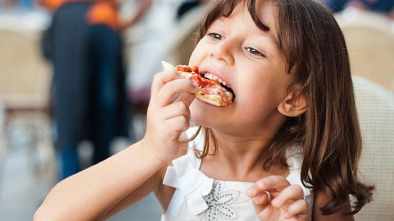 Child eating a slice of pizza