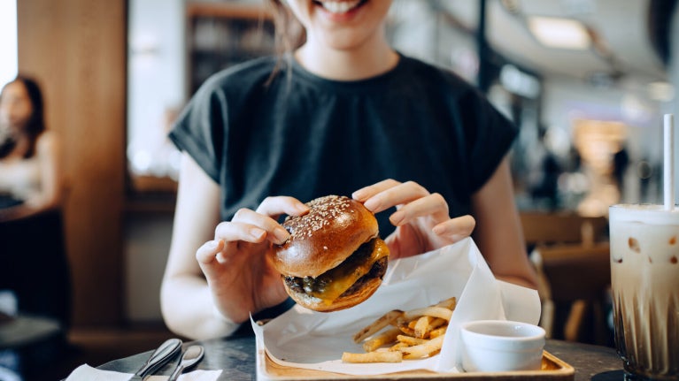 young girl eating a burger