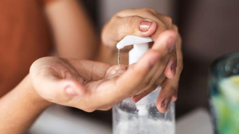 Woman pumping sanitizer into her hand