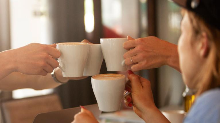 Coffee mugs being raised