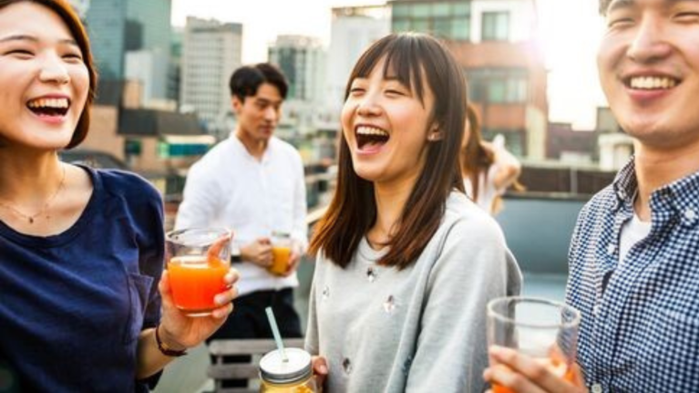 People laughing while holding beverages