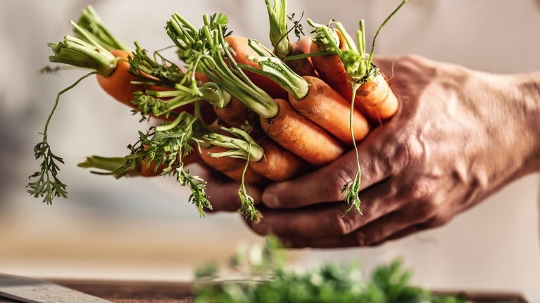 Man holding carrots in his hands