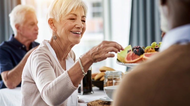 woman and man at table with fruit being served