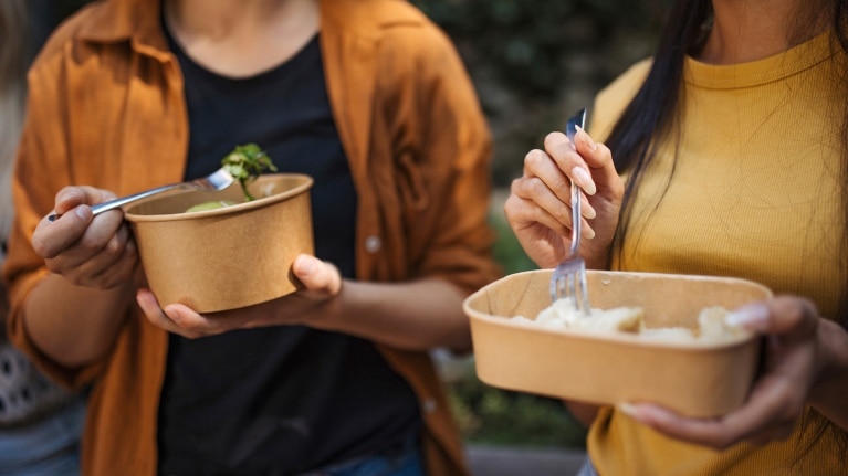 Two people eating out of take out containers