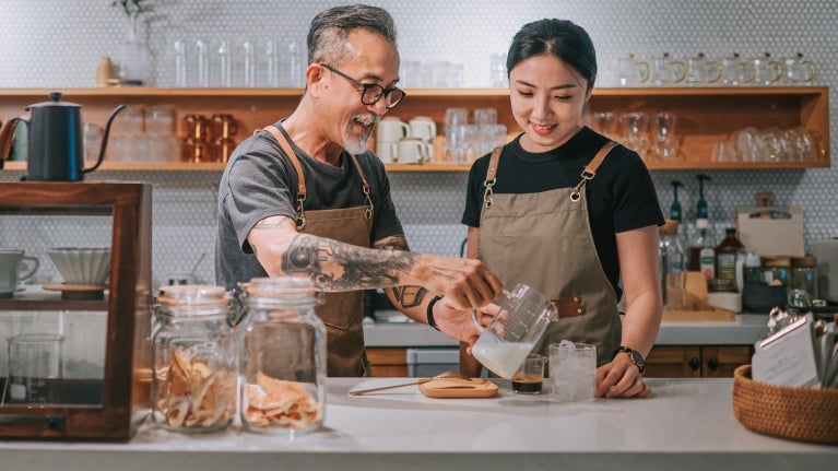 man and woman behind a counter pouring drinks