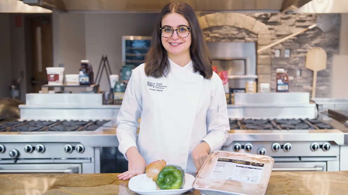 Chef Jordan standing in chef coat with green pepper onion salisbury steak