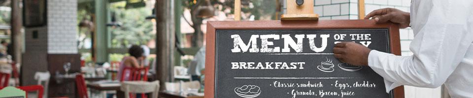 chef updating an outdoor menu board