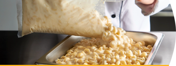 White Cheddar Macaroni and Cheese being poured into stainless steel pan