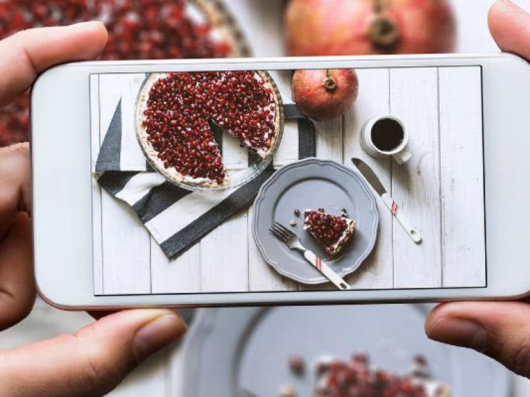 Smart phone capturing plate of dessert with beverage