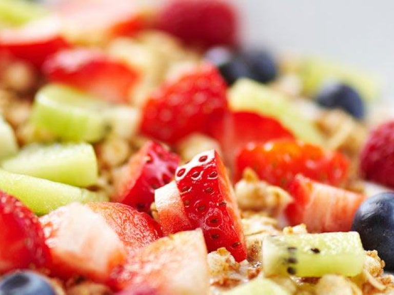 Breakfast plate with fresh fruit on muesli and yogurt