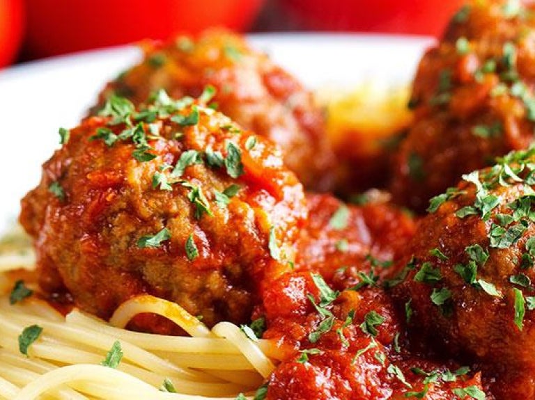 Plate of spaghetti and meatballs with garnish