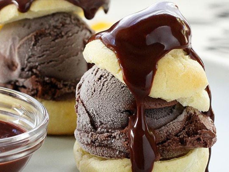 Plate of profiteroles with side of chocolate sauce