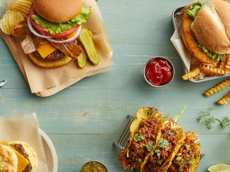 Vegan burger and tacos with drinks photographed overhead