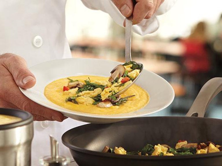 Cook serving up a dish of catered food