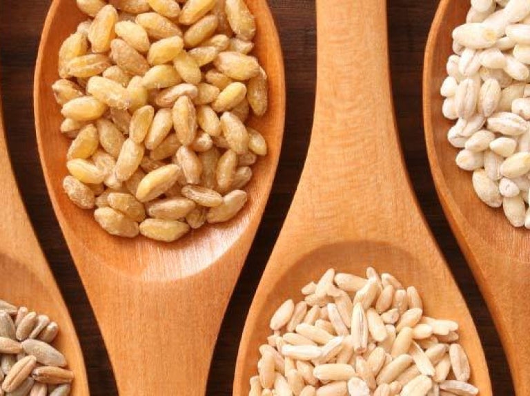 Assorted grains in wooden serving spoons