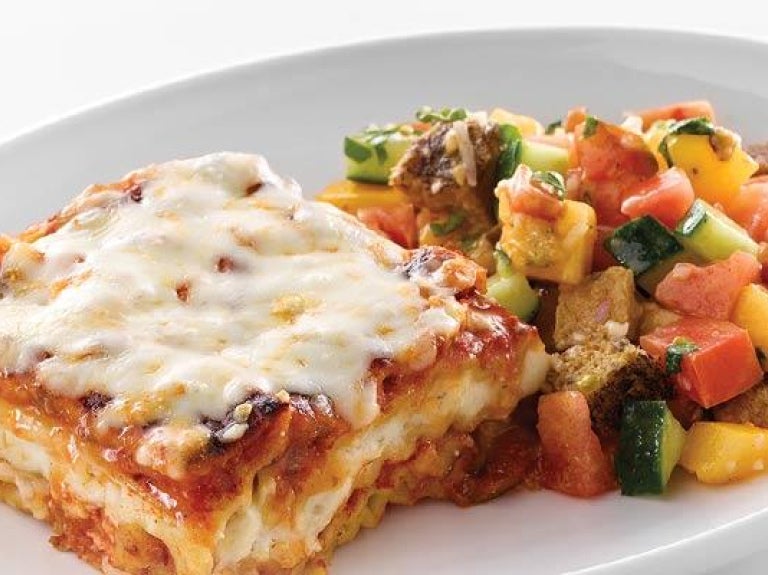 Plate of whole grain lasagna with meat sauce and grilled panzanella salad