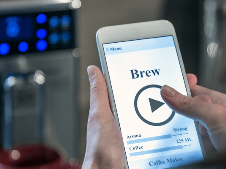Person using smart phone to brew coffee
