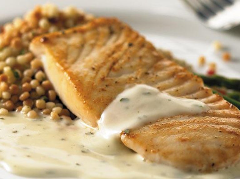Plate of salmon with basil and creamy alfredo sauce