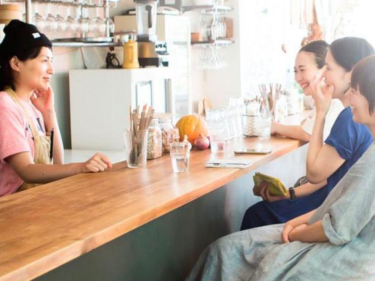 Women sitting at a cafe counter with iced lattes