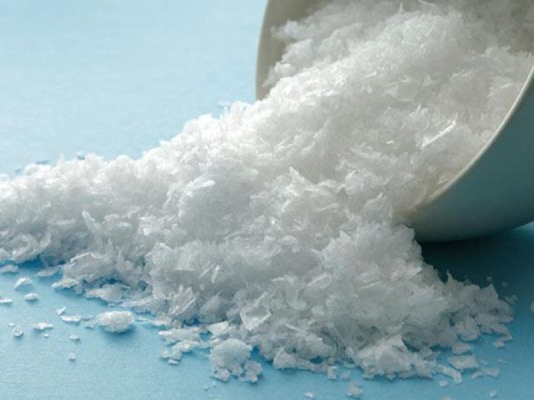 Bowl of salt poured onto blue surface