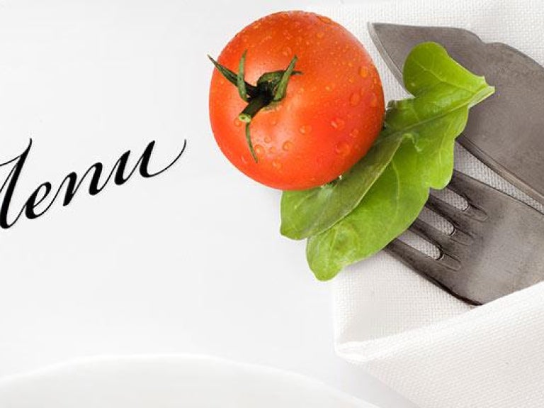 Table setting and menu with tomato and greens