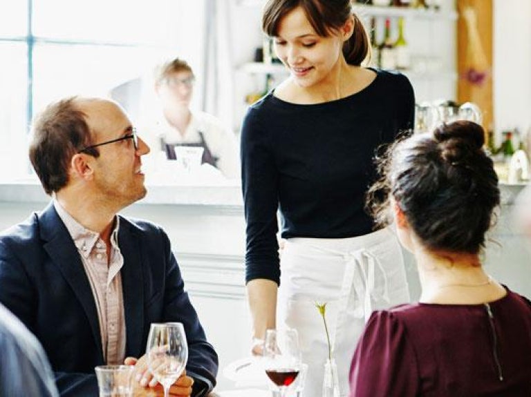 Waitress offering drinking suggestion to customers
