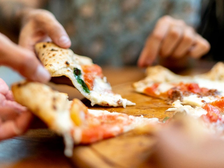 people eating slices of pizza