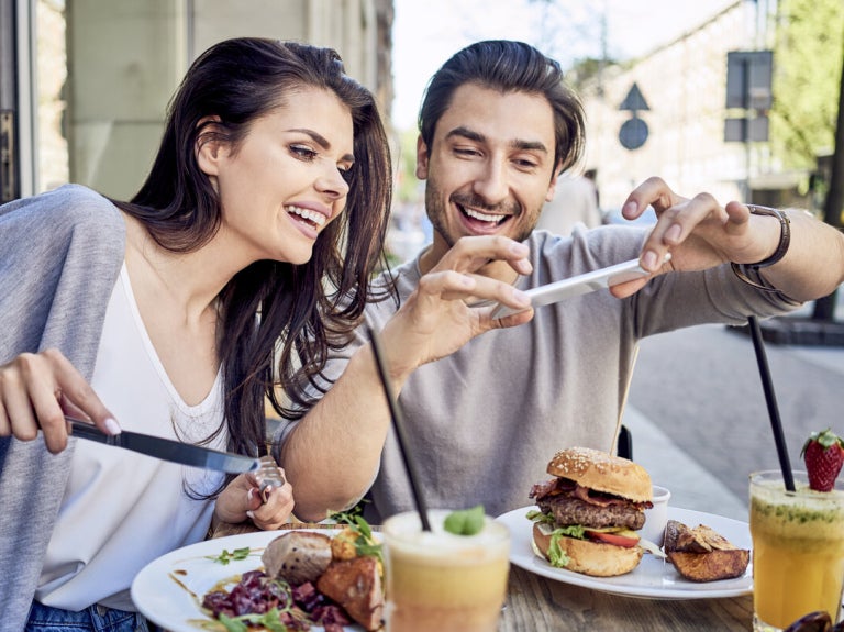 couple taking a picture of their food