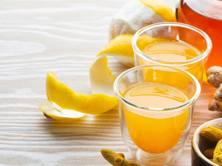 Lemon peel and glasses of juice on table