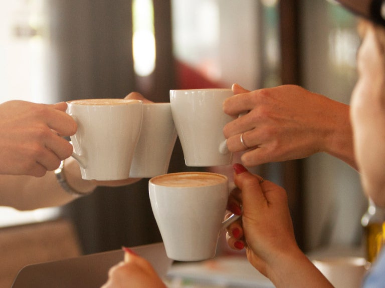 Coffee mugs being raised