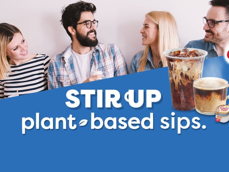 Two men and two women smiling and looking at each other. Test says "Stir up plant-based sips."