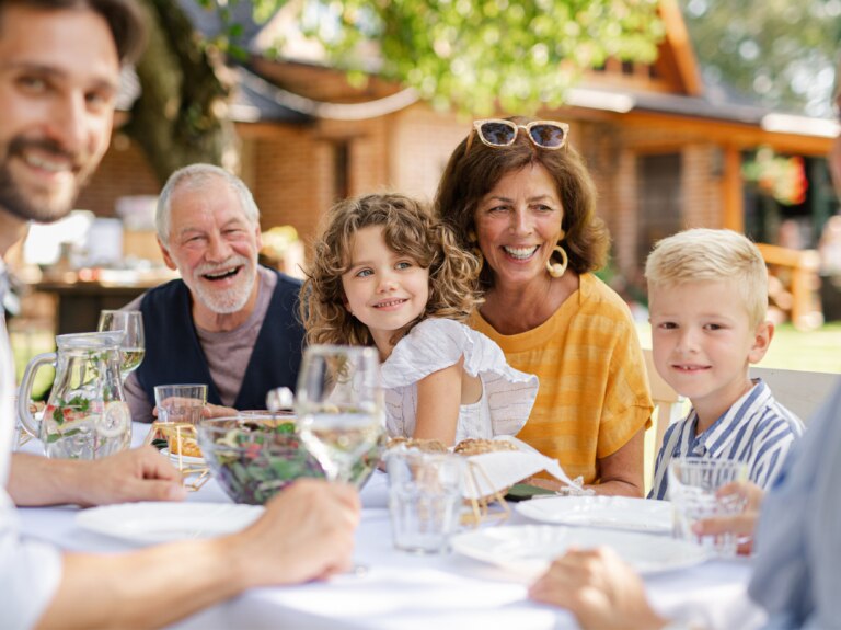 Three generations eating together at an outdoor dinner table