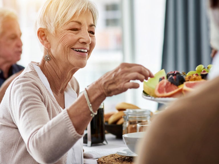 woman and man at table with fruit being served