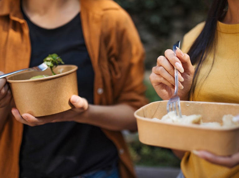 Two people eating out of take out containers