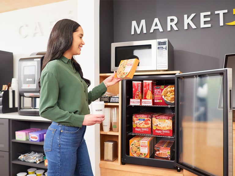 woman standing and reaching for a grab and go product