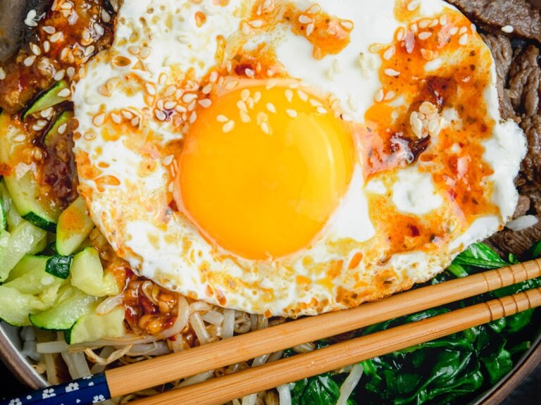 over easy egg on top of greens in bowl