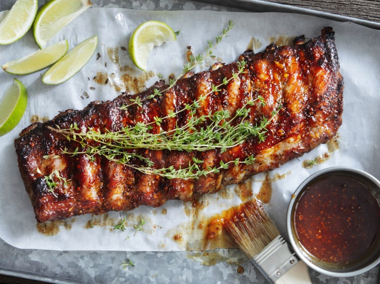 slab of barbecue ribs on parchment paper on metal tray