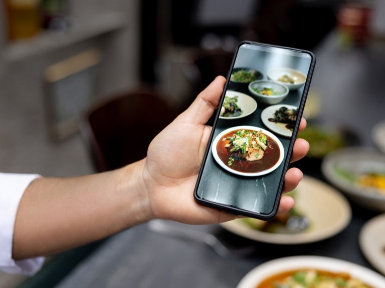 Sustainability person holding cell phone with image of food