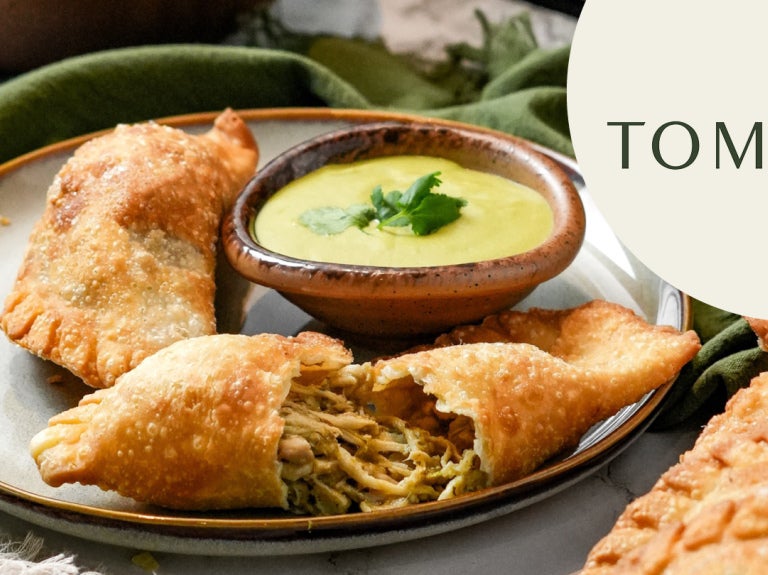 Tooma empanadas open on plate with sauce