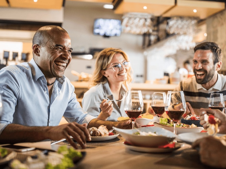 October trend report holiday foodservice people sitting around table sharing food