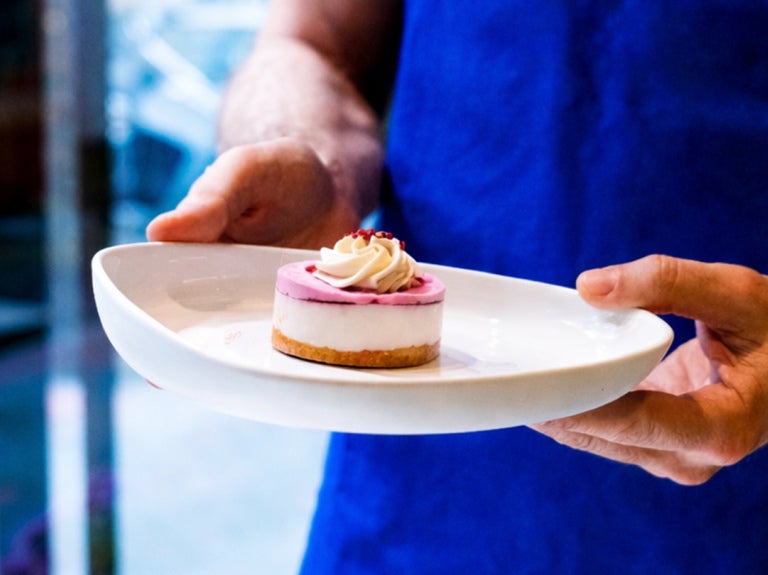 Customer holding a mini cheesecake dessert