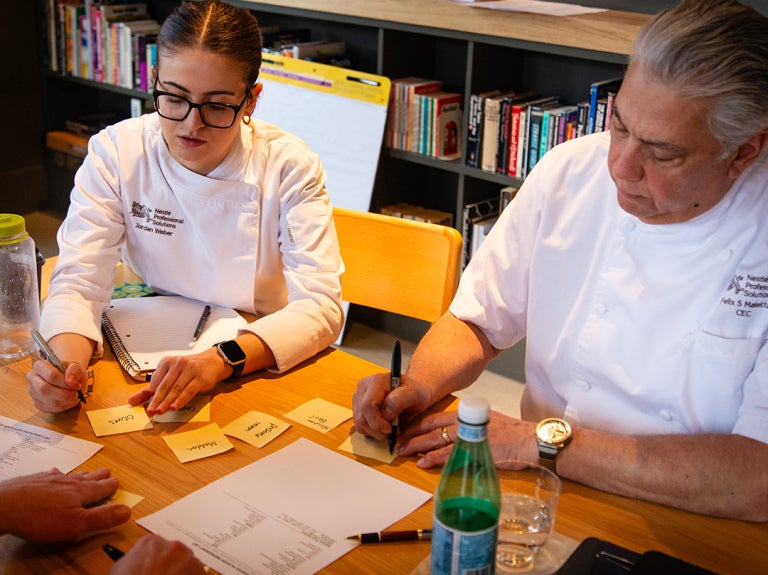 chefs at table writing down information