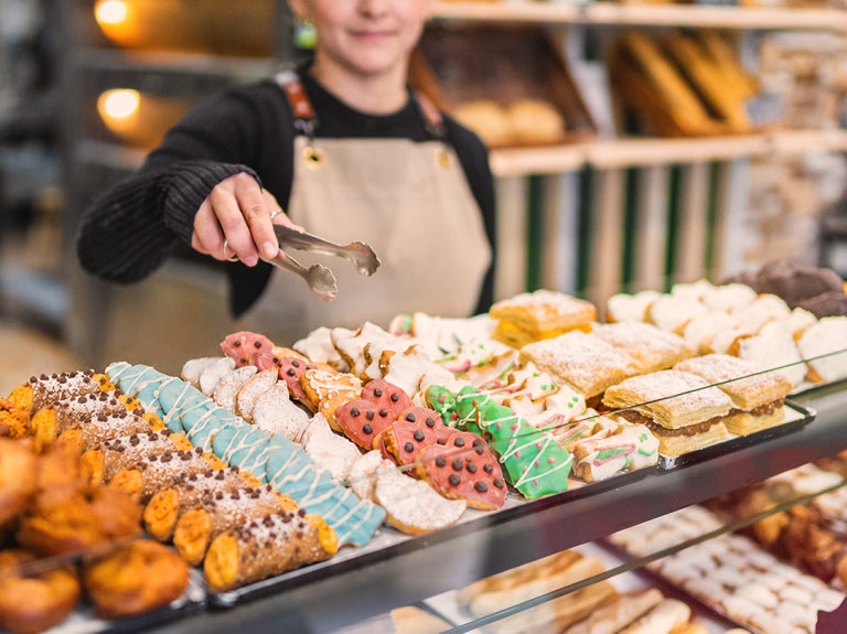 Bakery case with cannolis, cookies and donuts.