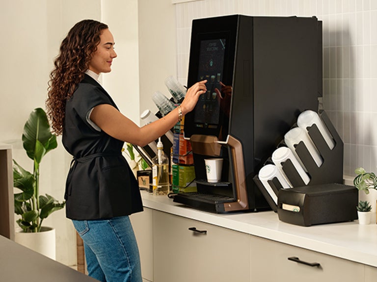 woman making coffee selection at starbucks machine