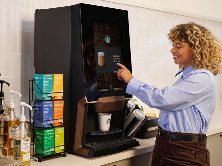 woman filling cup at starbucks machine