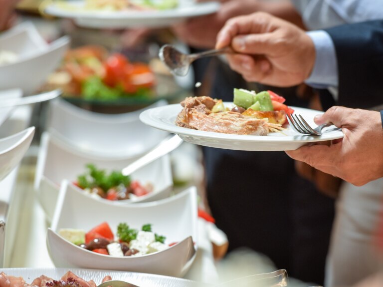 hotel guest adding food from buffet to plate