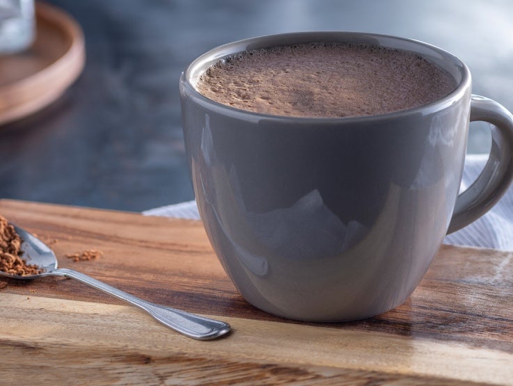 Hot cocoa in a cup with cocoa on spoon