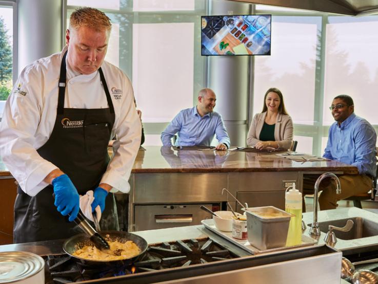 Chef cooking with customers in background