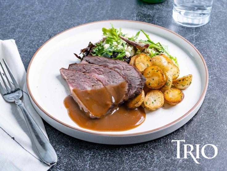 Trio Brown Gravy on top of steak on a white plate